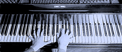 hands playing piano keyboard from above